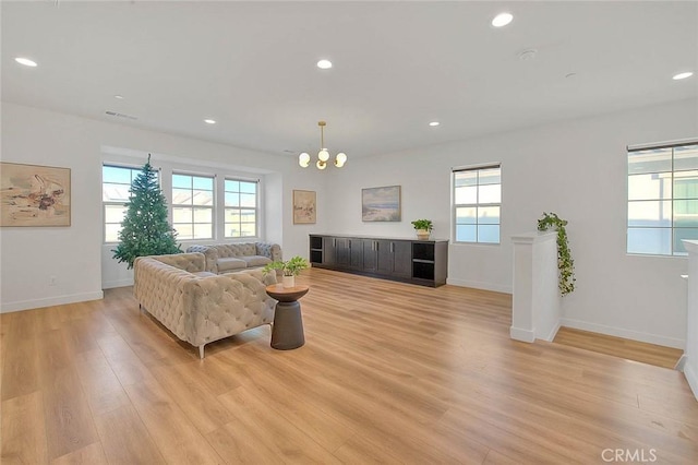 living room featuring an inviting chandelier and light hardwood / wood-style flooring