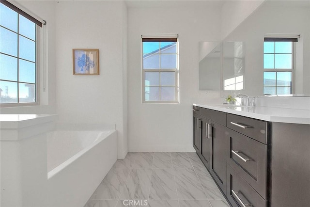 bathroom with vanity, plenty of natural light, and a bathtub