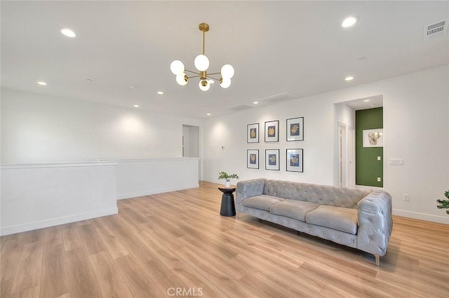 living room with light hardwood / wood-style flooring and a chandelier