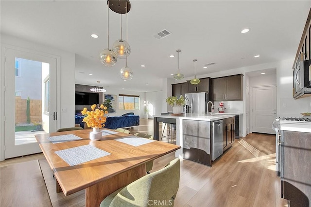 dining space featuring sink and light wood-type flooring