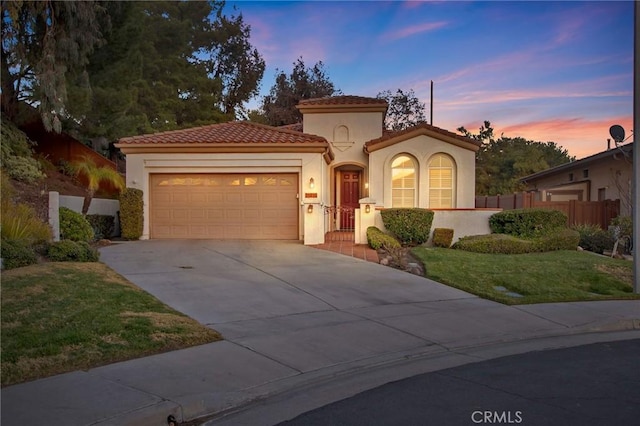 mediterranean / spanish-style house featuring a garage and a yard