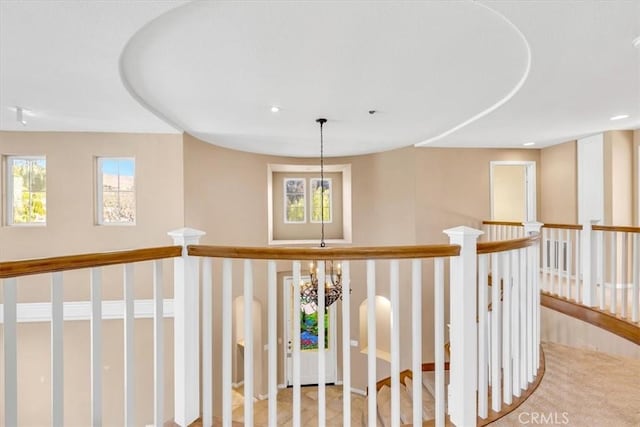 hallway with an inviting chandelier and plenty of natural light