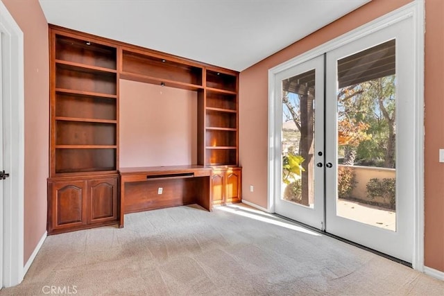 unfurnished living room with light carpet and french doors