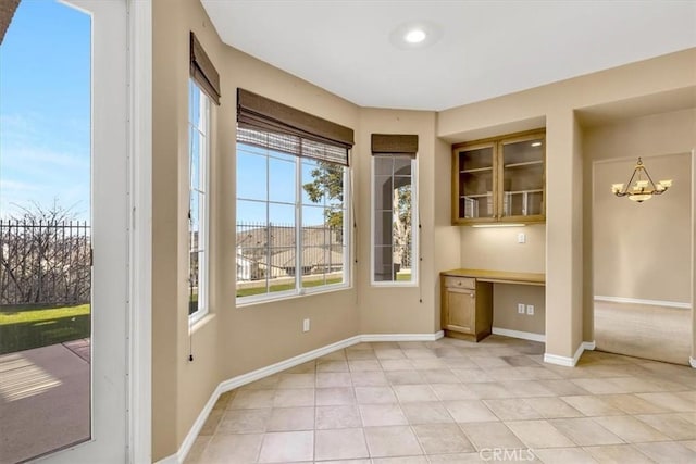 entryway featuring an inviting chandelier, built in desk, and light tile patterned floors