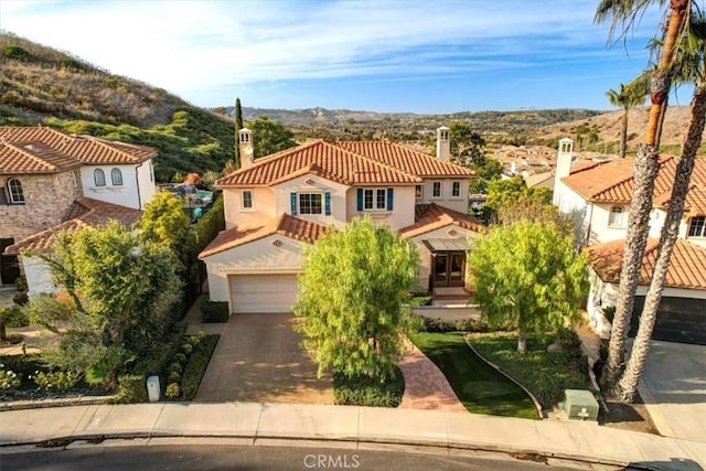 mediterranean / spanish-style house with a garage and a mountain view