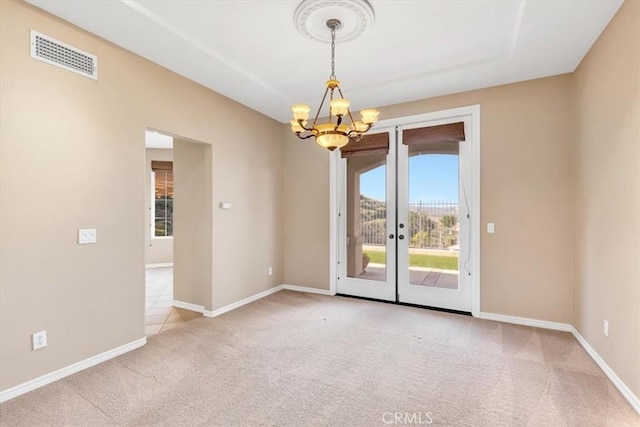 carpeted spare room with a chandelier