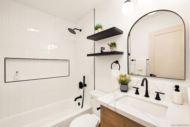 full bathroom featuring tiled shower / bath, vanity, and toilet