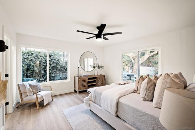 bedroom featuring multiple windows, ceiling fan, and light hardwood / wood-style flooring