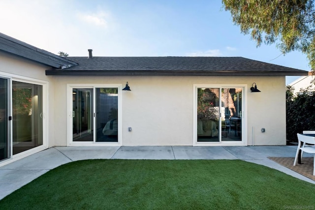 back of house with a yard and a patio