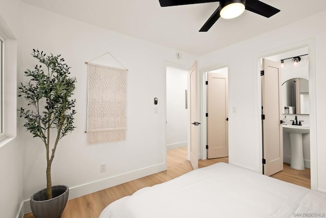 bedroom with connected bathroom, hardwood / wood-style flooring, sink, and ceiling fan