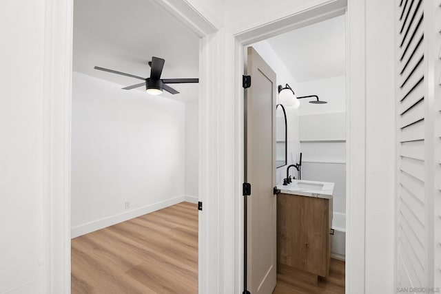 bathroom featuring ceiling fan, vanity, and wood-type flooring