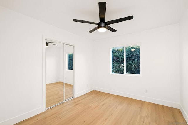 unfurnished bedroom with hardwood / wood-style floors, a closet, and ceiling fan