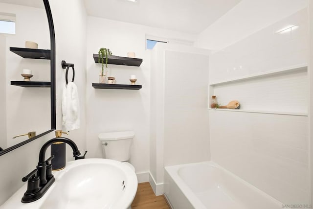 full bathroom with sink, hardwood / wood-style flooring, tub / shower combination, and toilet