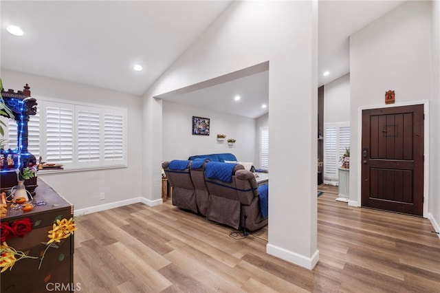 bedroom featuring high vaulted ceiling and light hardwood / wood-style floors