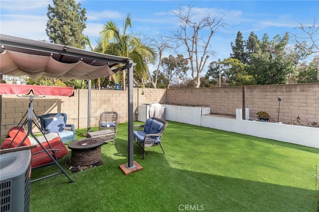 view of yard featuring a fire pit and central AC