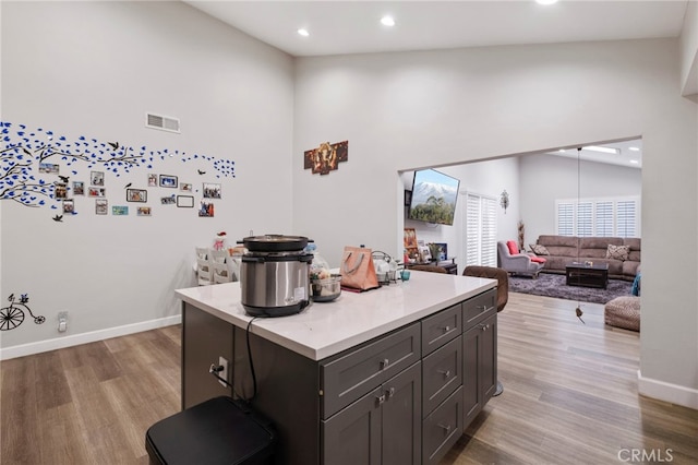 kitchen featuring a kitchen island, lofted ceiling, and light hardwood / wood-style floors