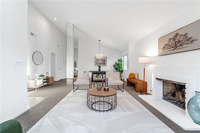 living room with high vaulted ceiling, a fireplace, and light colored carpet