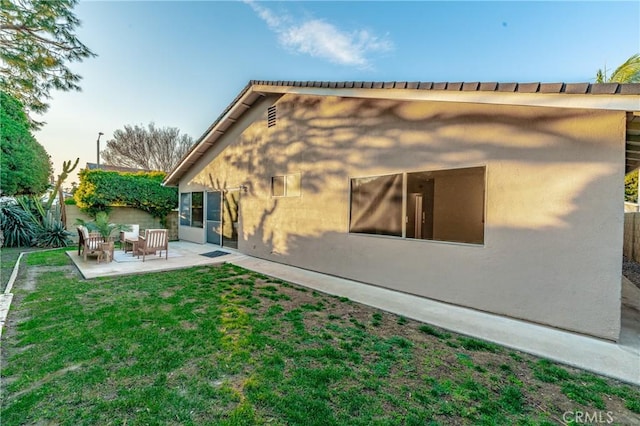 rear view of house with a patio area and a lawn