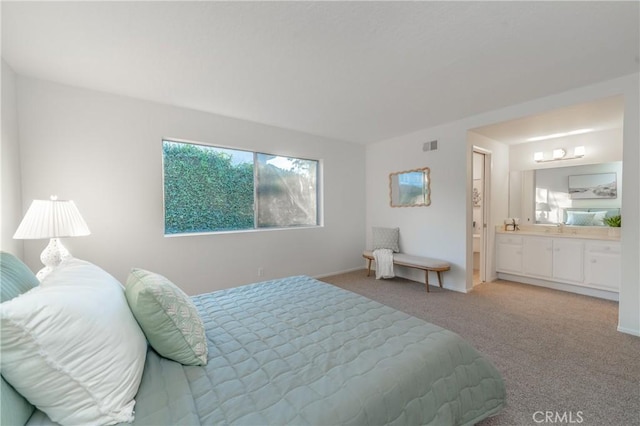 bedroom featuring sink, ensuite bath, and carpet floors