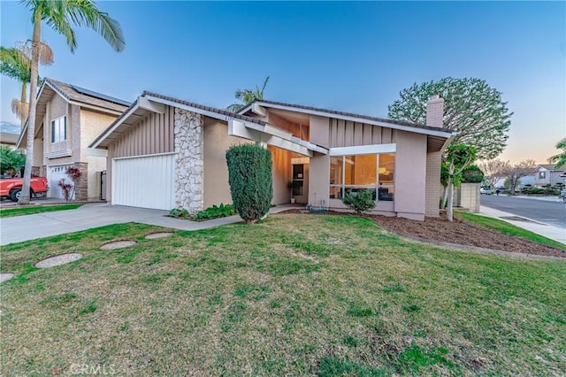 view of front of property with a garage and a lawn