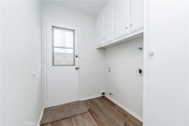 washroom with cabinets, hookup for an electric dryer, and light hardwood / wood-style floors