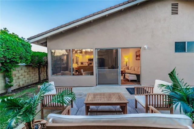 back of house with an outdoor living space and a patio