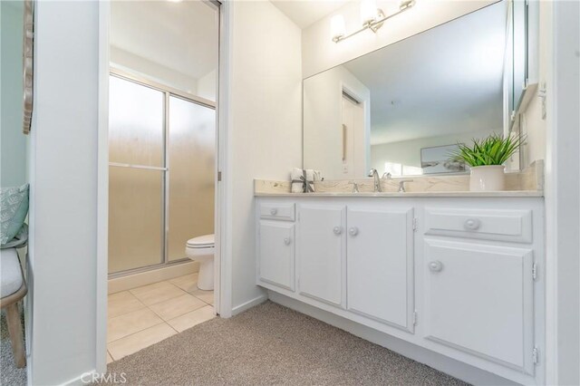 bathroom with vanity, toilet, an enclosed shower, and tile patterned flooring