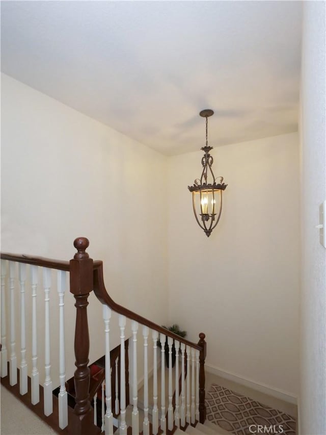 stairway with a notable chandelier