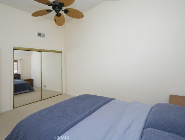 bedroom featuring lofted ceiling, carpet floors, a closet, and ceiling fan