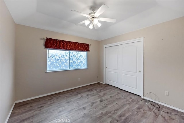 unfurnished bedroom featuring ceiling fan, a closet, and light hardwood / wood-style flooring