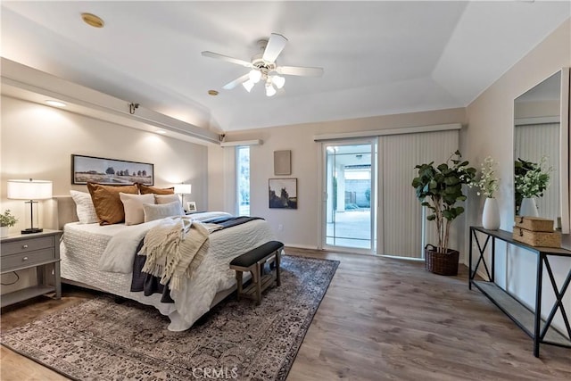 bedroom with hardwood / wood-style flooring, ceiling fan, a tray ceiling, and access to outside