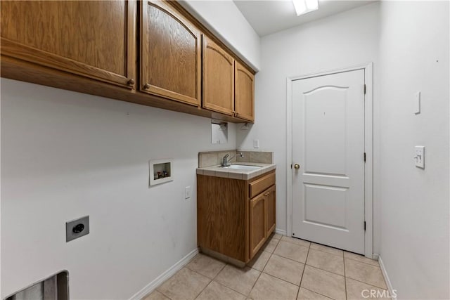 clothes washing area featuring sink, cabinets, light tile patterned floors, electric dryer hookup, and washer hookup