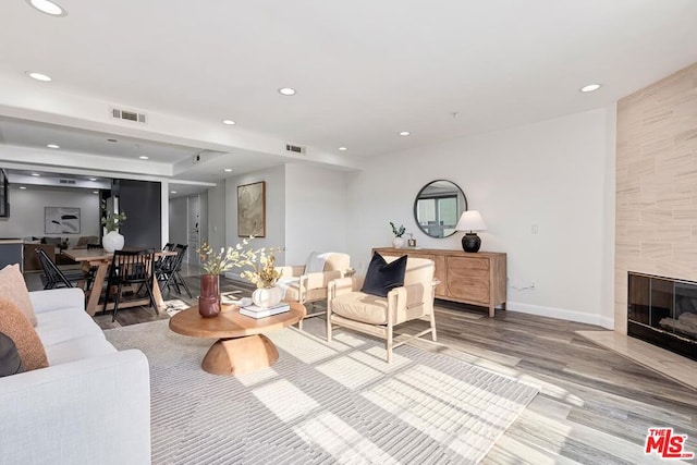 living room featuring light hardwood / wood-style floors and a tile fireplace