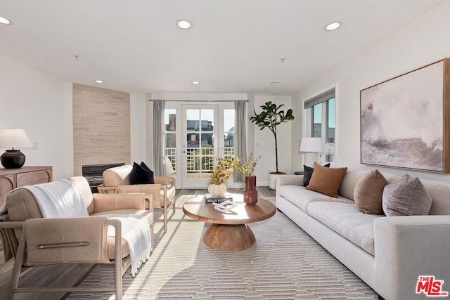 living room featuring a tiled fireplace and hardwood / wood-style flooring