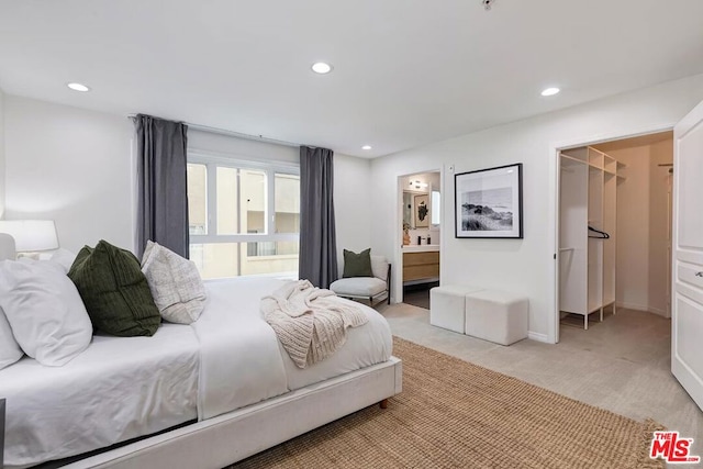 carpeted bedroom featuring a spacious closet and connected bathroom