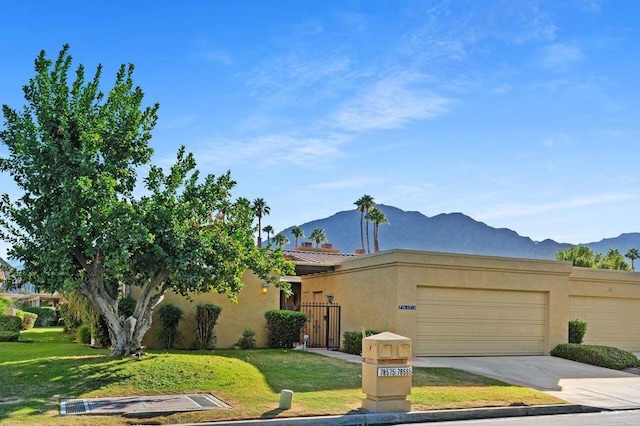 view of front of property featuring a garage, a mountain view, and a front yard