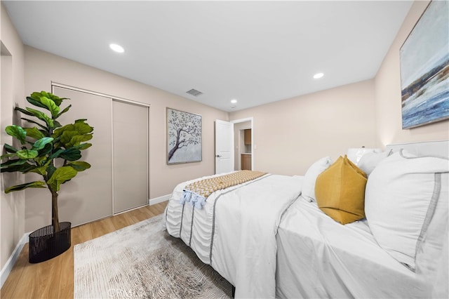 bedroom with light wood-type flooring and a closet