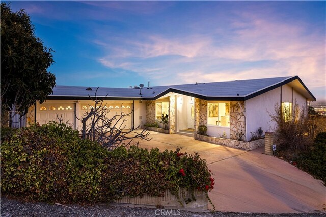 single story home featuring a garage and solar panels