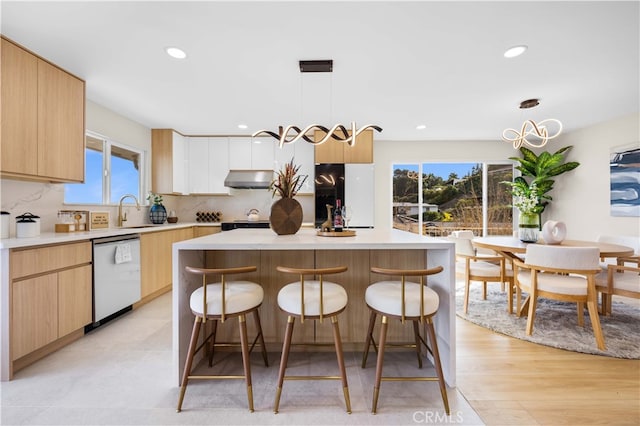 kitchen with pendant lighting, tasteful backsplash, stainless steel dishwasher, and a kitchen island