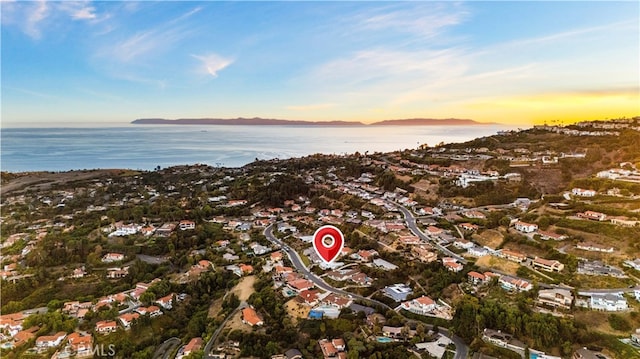 aerial view at dusk featuring a water view