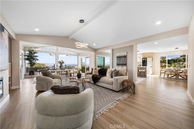 living room featuring light hardwood / wood-style floors and vaulted ceiling with beams