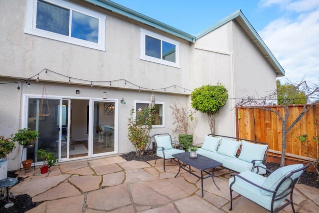 back of house featuring an outdoor living space and a patio