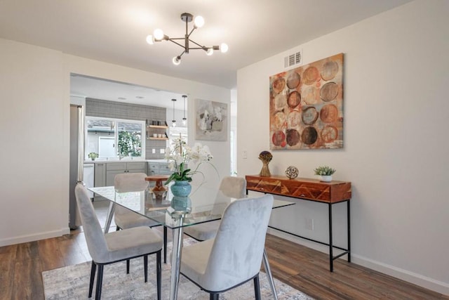 dining area featuring hardwood / wood-style floors and a notable chandelier