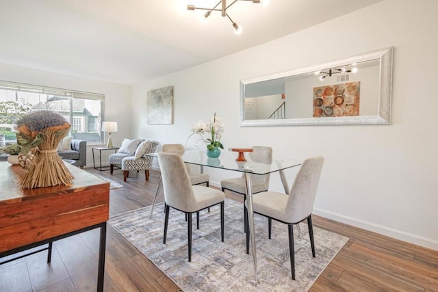 dining space featuring hardwood / wood-style floors and a chandelier