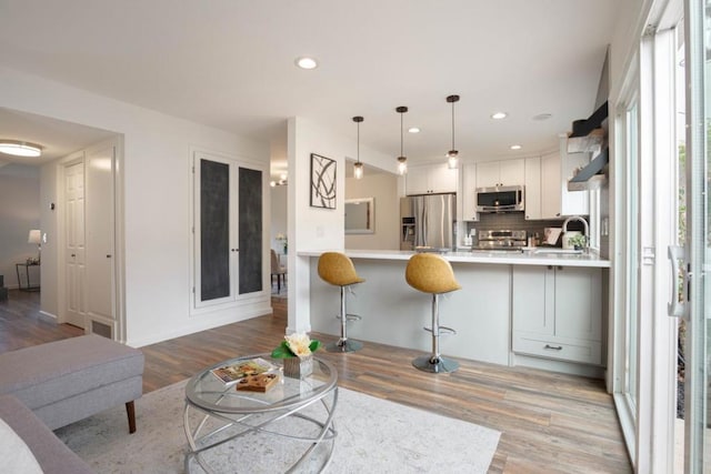 living room featuring sink and light hardwood / wood-style floors