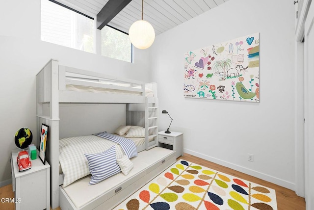 bedroom with light hardwood / wood-style flooring, wooden ceiling, and beamed ceiling