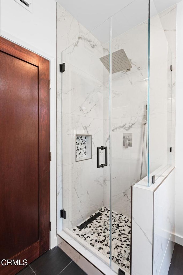 bathroom with a shower with door