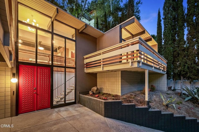 property exterior at dusk with a balcony