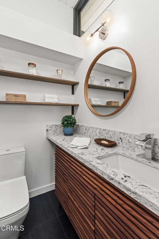 bathroom with tile patterned flooring, vanity, and toilet