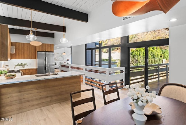 dining space featuring beamed ceiling, wood ceiling, sink, and light hardwood / wood-style flooring